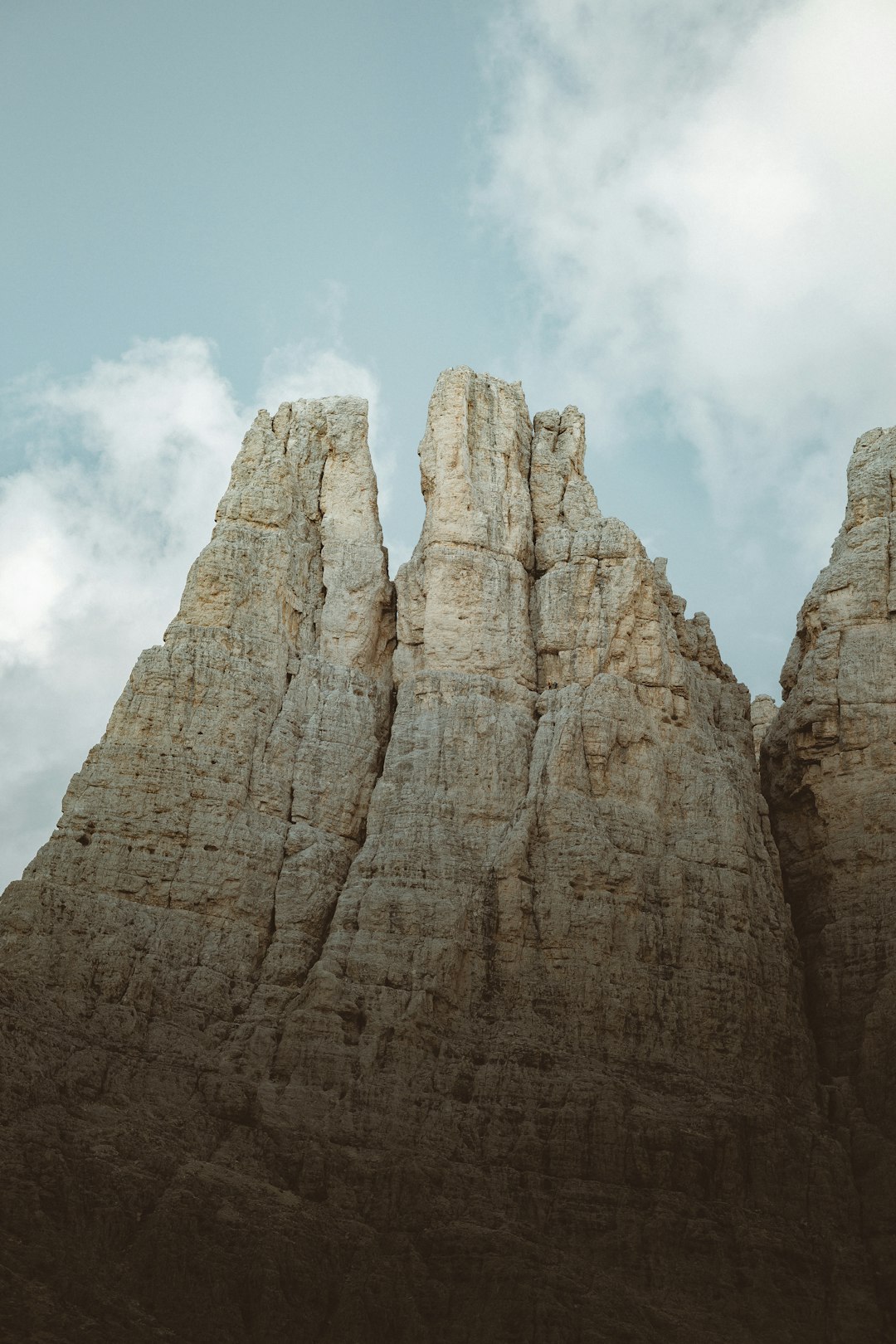 brown rock formation under white clouds during daytime