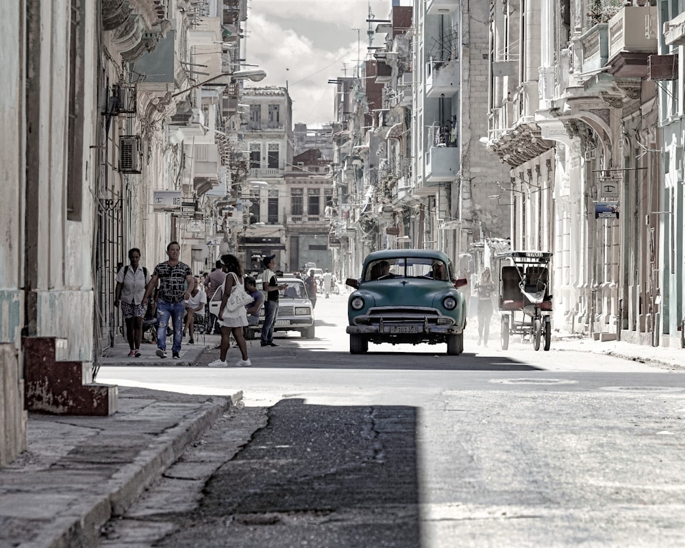 a car driving down a street next to tall buildings