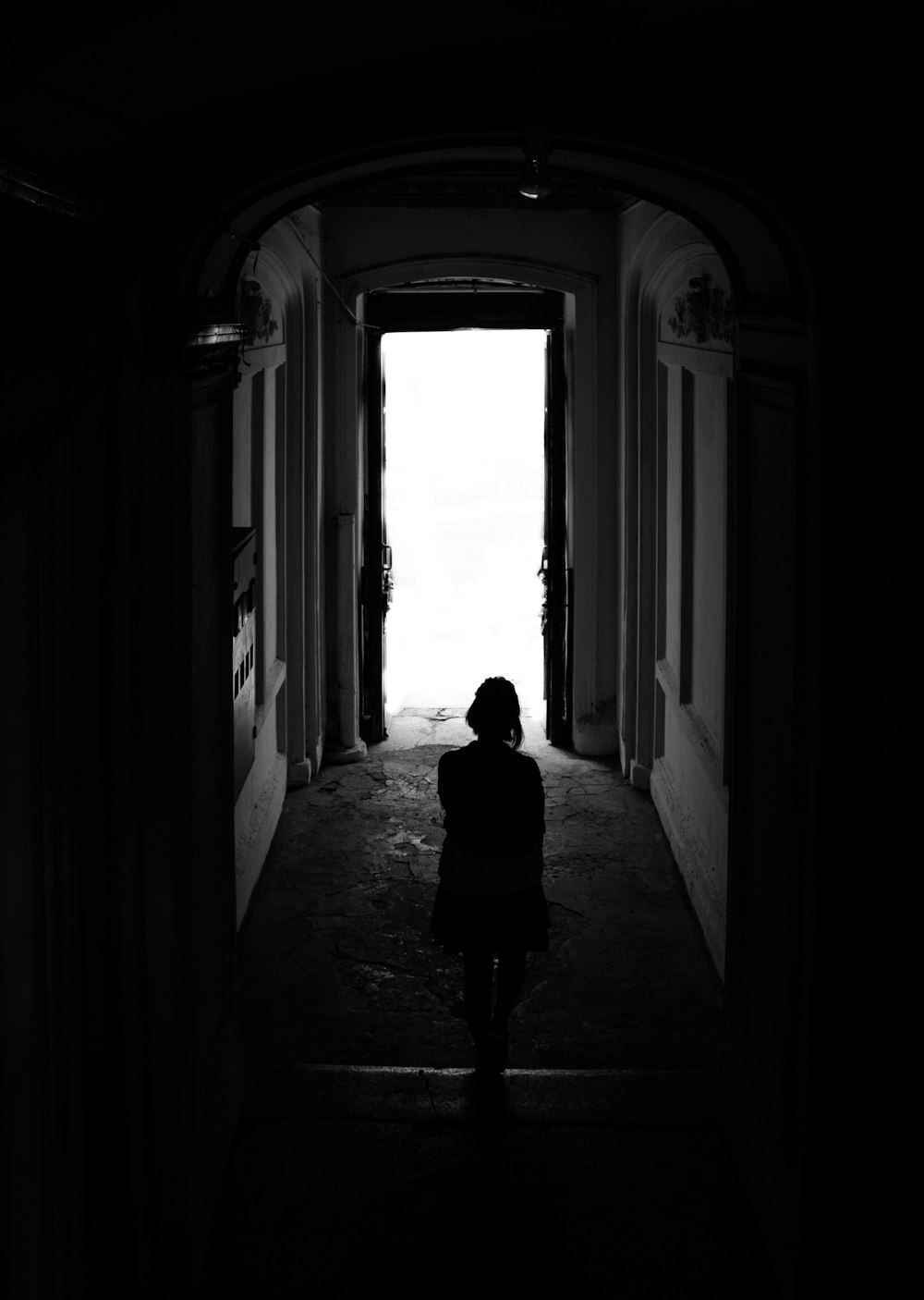 silhouette of woman walking on hallway