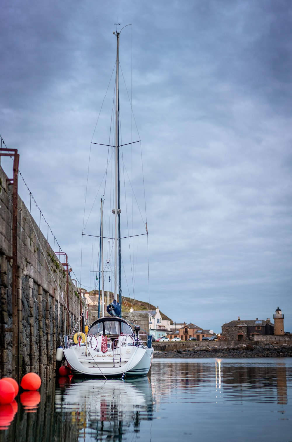 white boat on body of water near city buildings during daytime