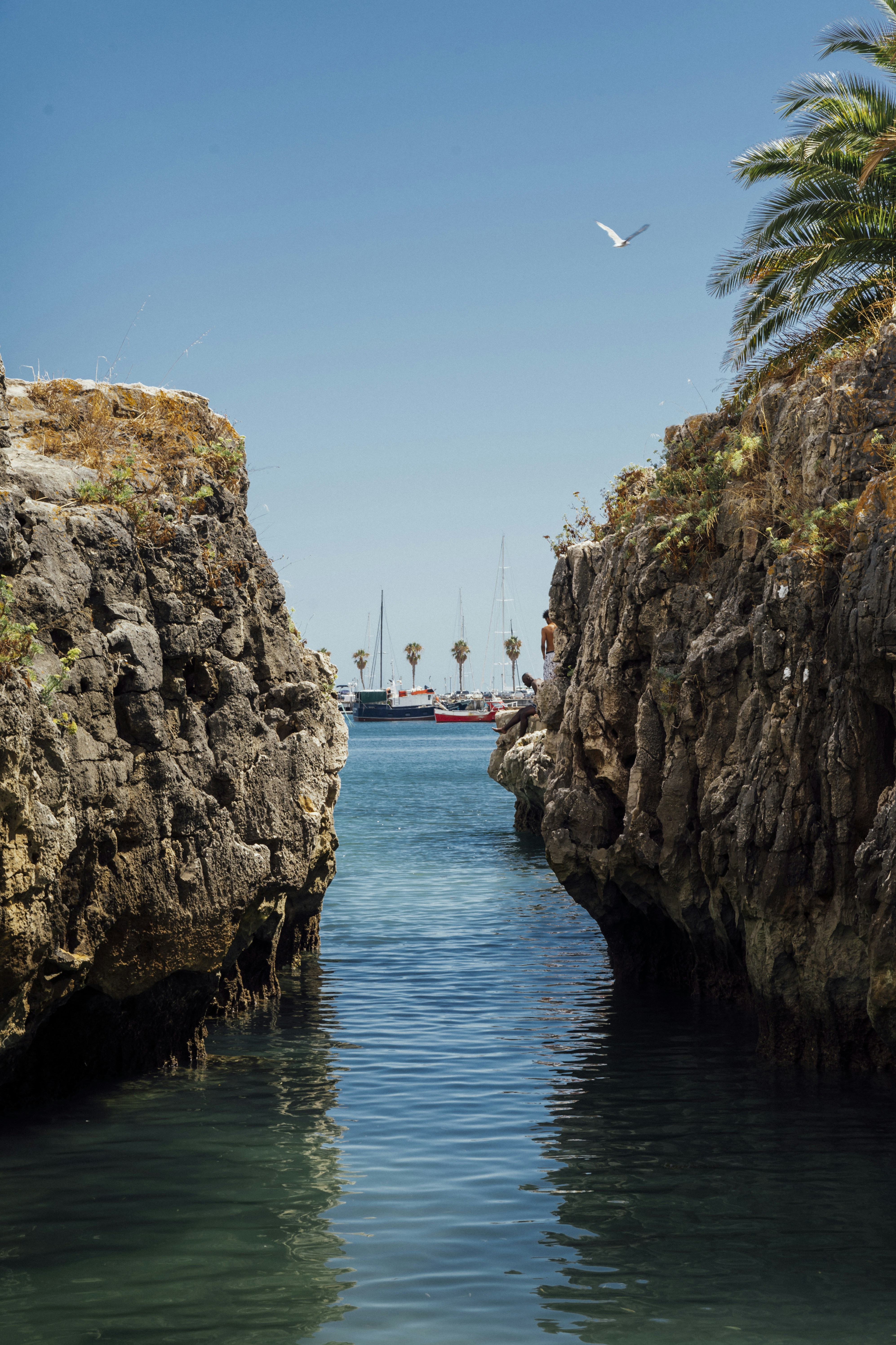 Braune Felsformation neben dem Gewässer tagsüber