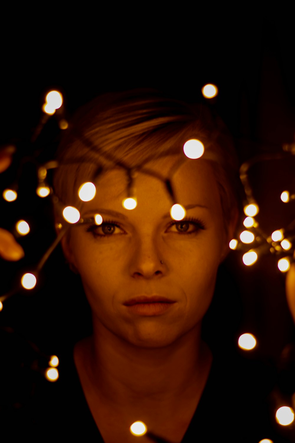 woman with yellow string lights on her face