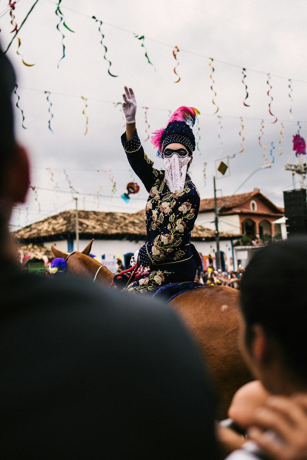 people in black and white floral long sleeve shirt raising hands during daytime