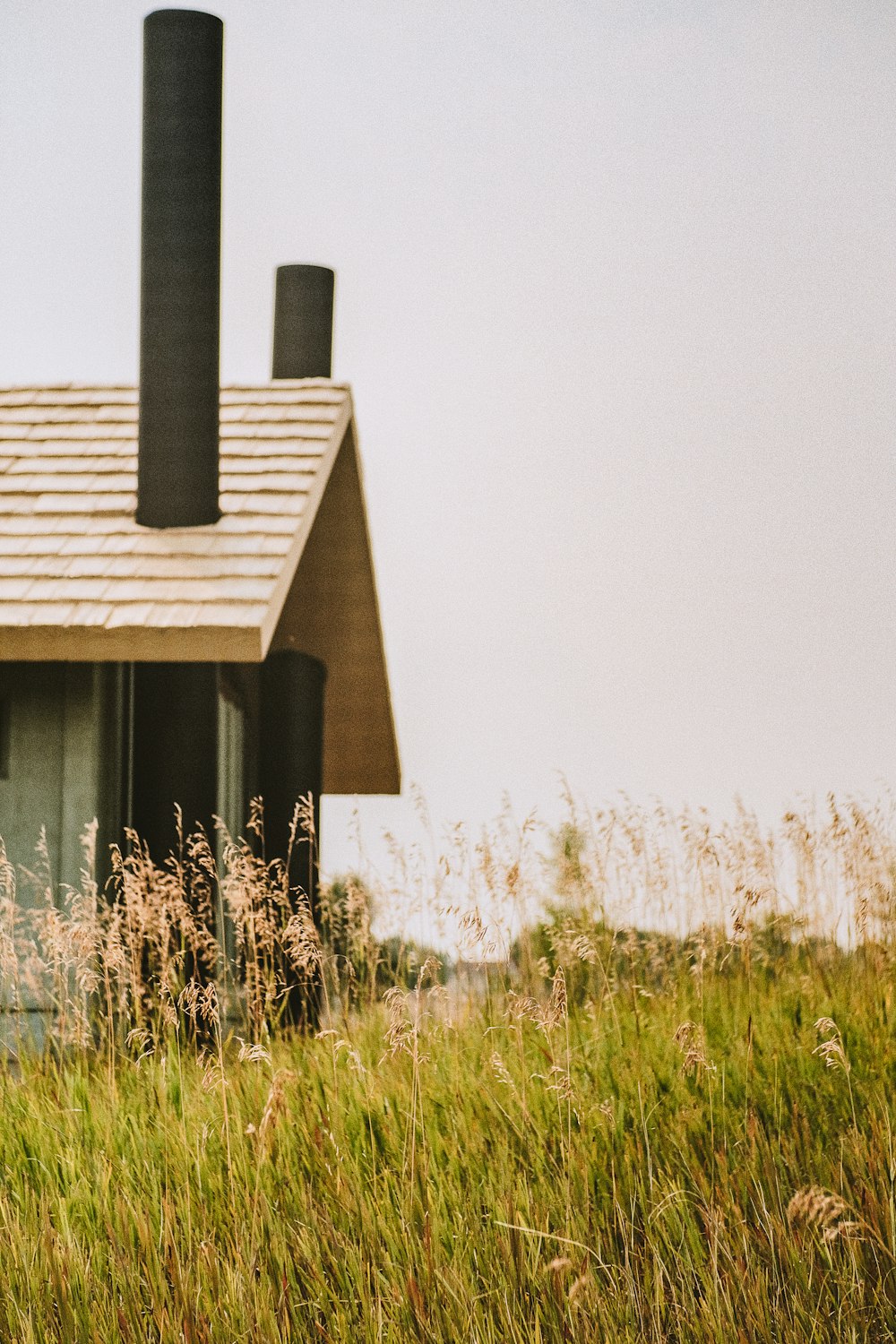 brown wooden house on green grass field during daytime