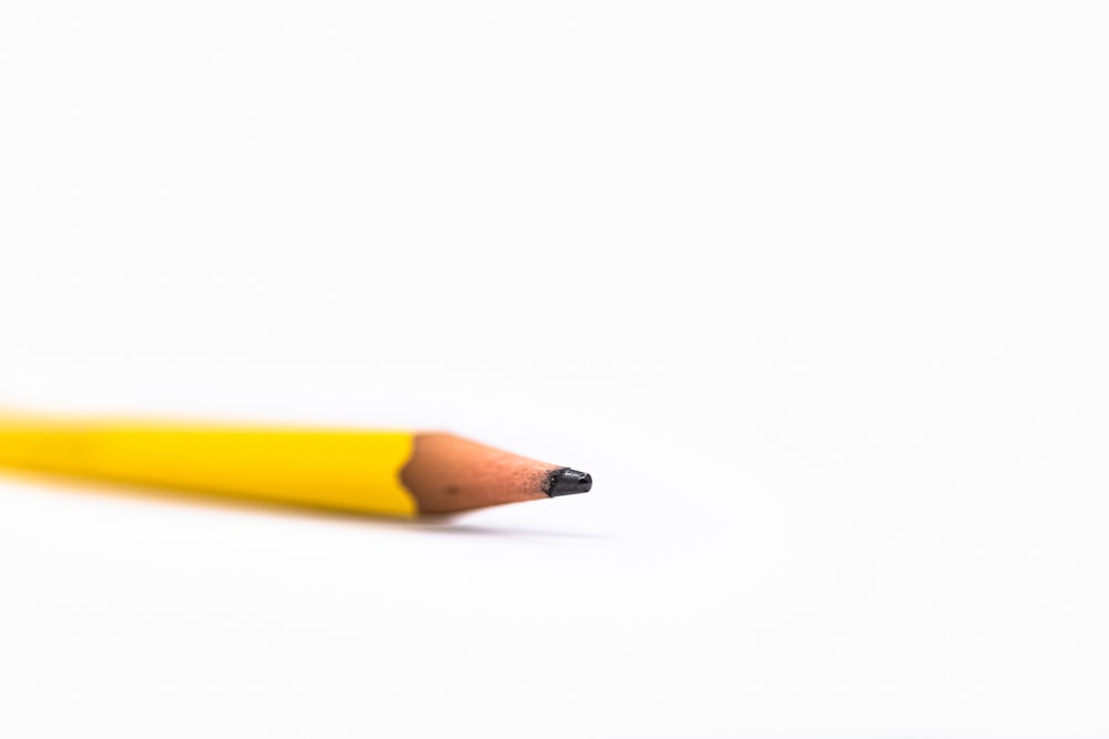 yellow pencil on white surface
