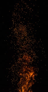 Bright flames and sparks rising against a dark background, creating a dynamic and intense visual effect.