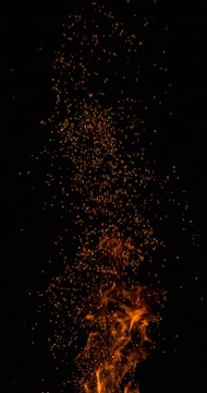 Bright flames and sparks rising against a dark background, creating a dynamic and intense visual effect.