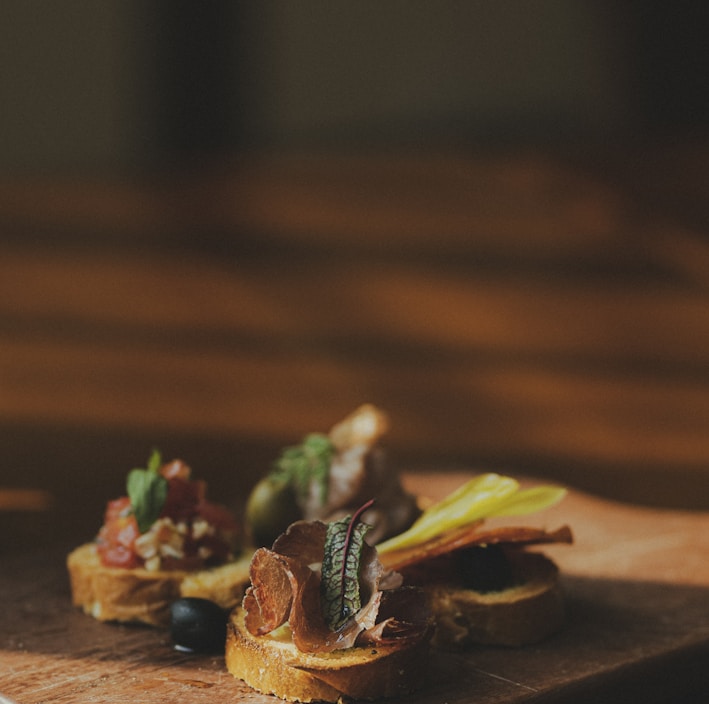 sliced meat with green vegetable on brown wooden chopping board