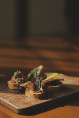 sliced meat with green vegetable on brown wooden chopping board