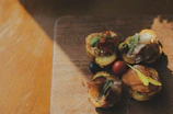 Close-up of gourmet appetizers arranged on a rustic wooden board.