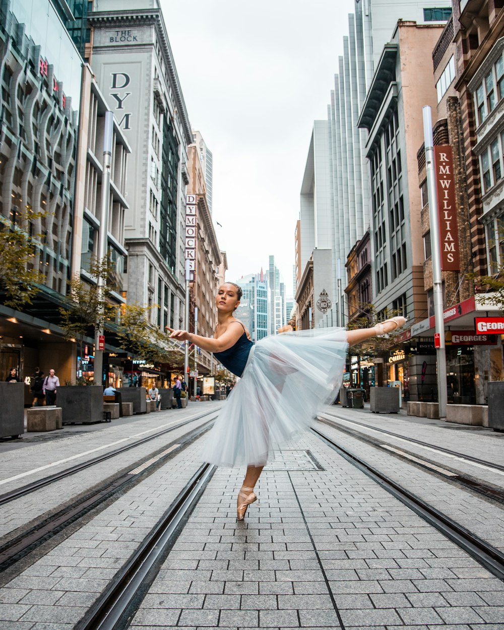 woman in white dress walking on sidewalk during daytime