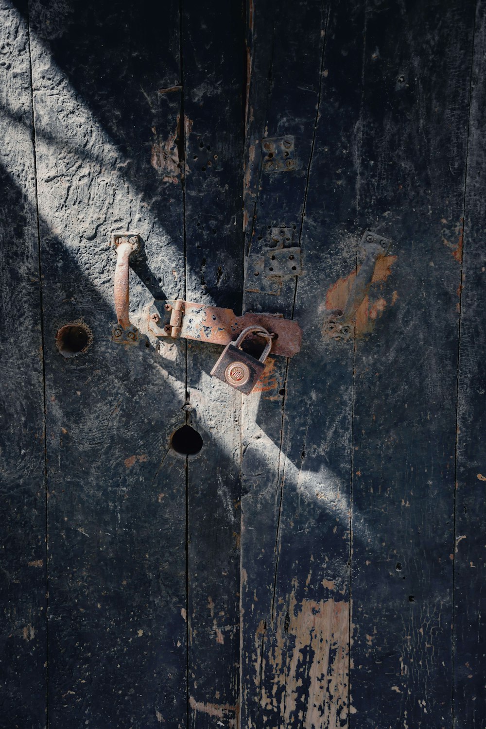 brown padlock on black wooden door