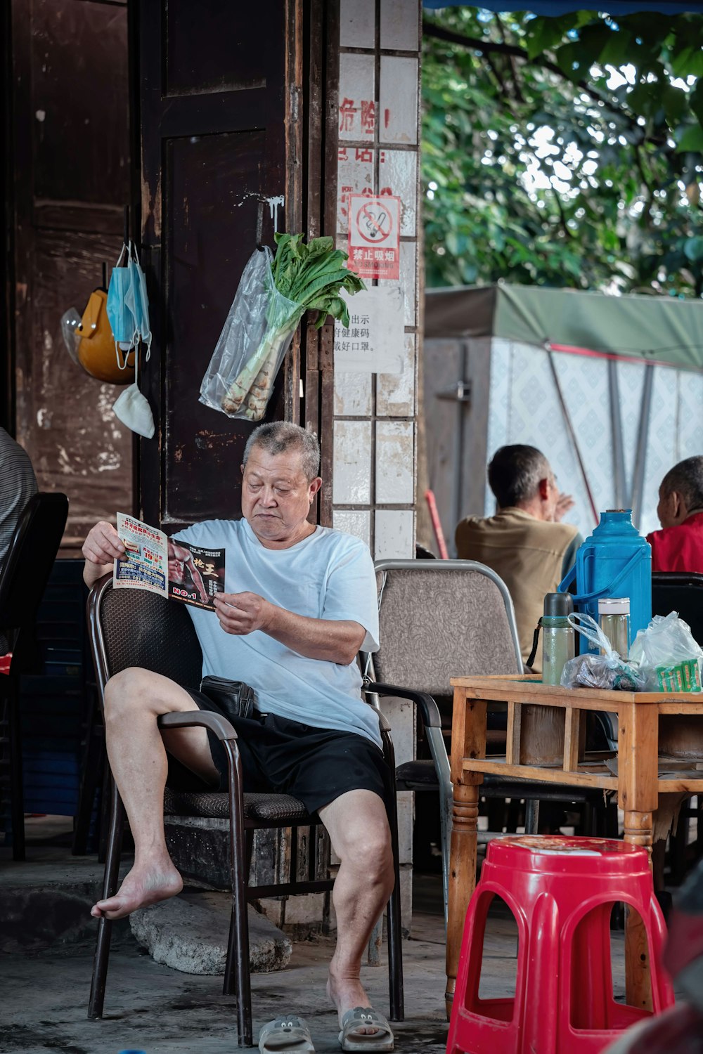 man in white crew neck t-shirt sitting on black armchair