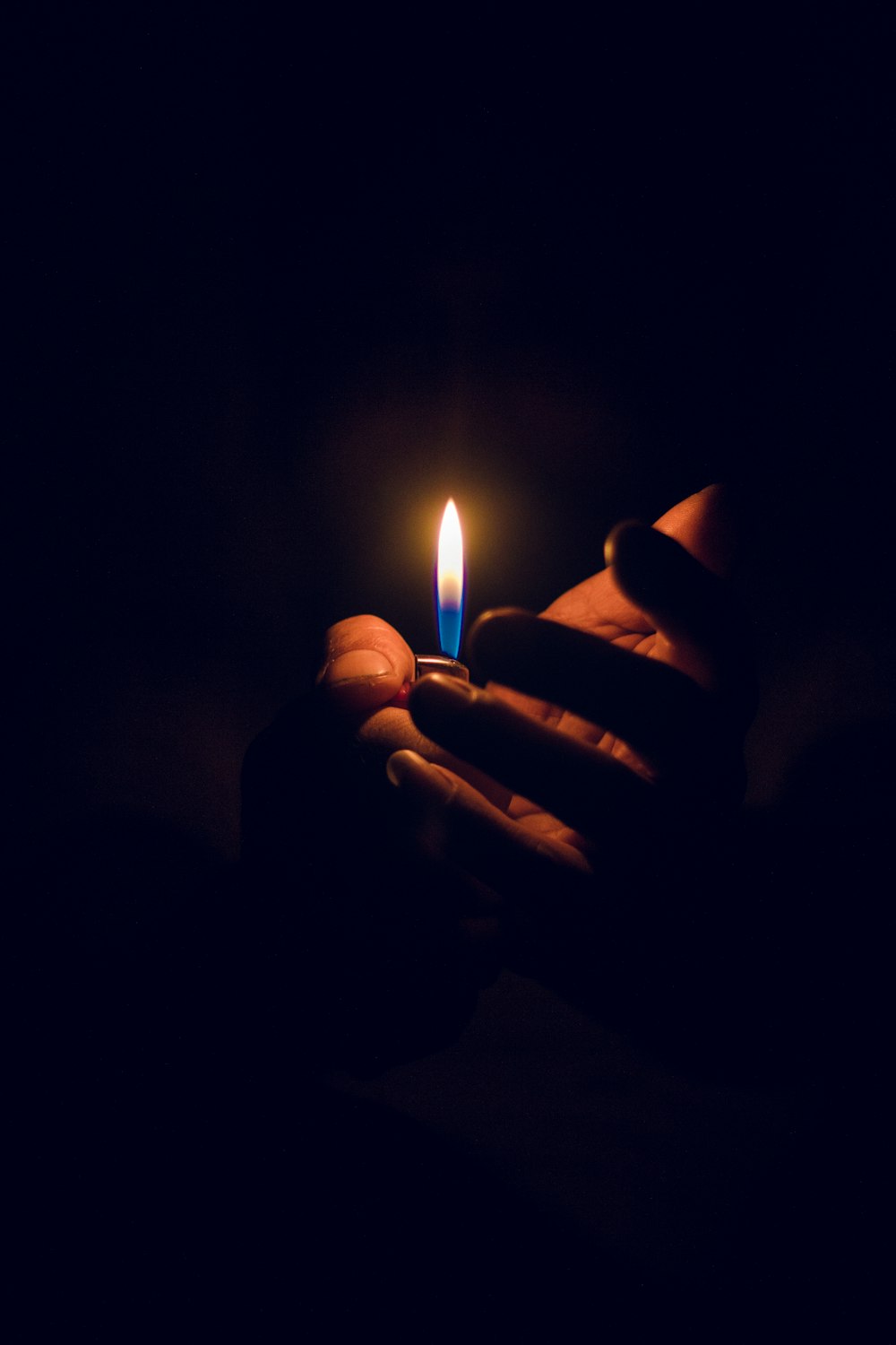 어두운 방에서 촛불을 들고 있는 사람