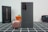 A Samsung smartphone is prominently displayed on a checkered surface with its camera lenses visible. Next to it is a small, round, metallic-looking case, likely for earbuds. In the background, a black box with 'N20' is partially visible, alongside an orange pot with a small green plant and a black object with red accents.