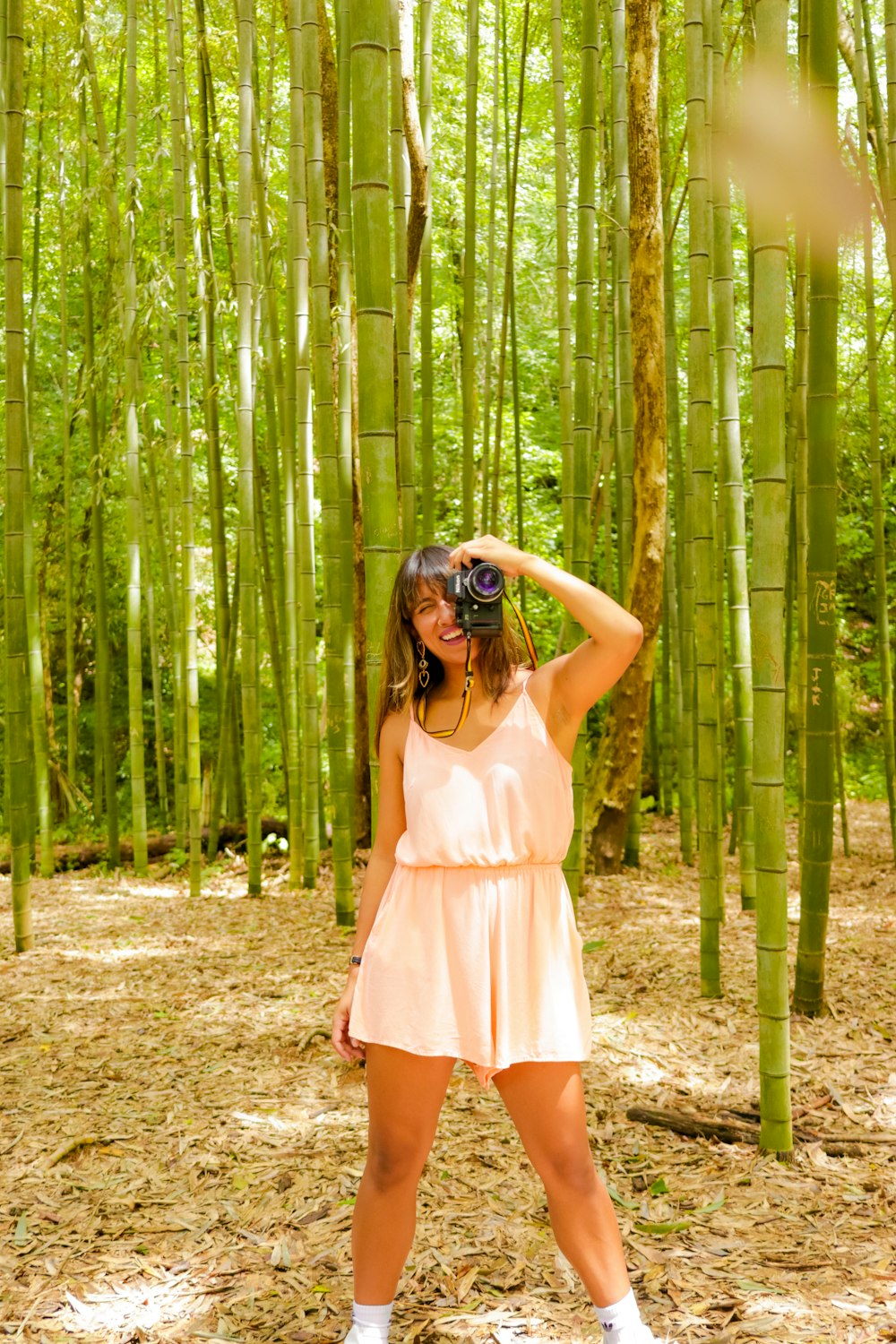 woman in pink sleeveless dress standing on forest during daytime