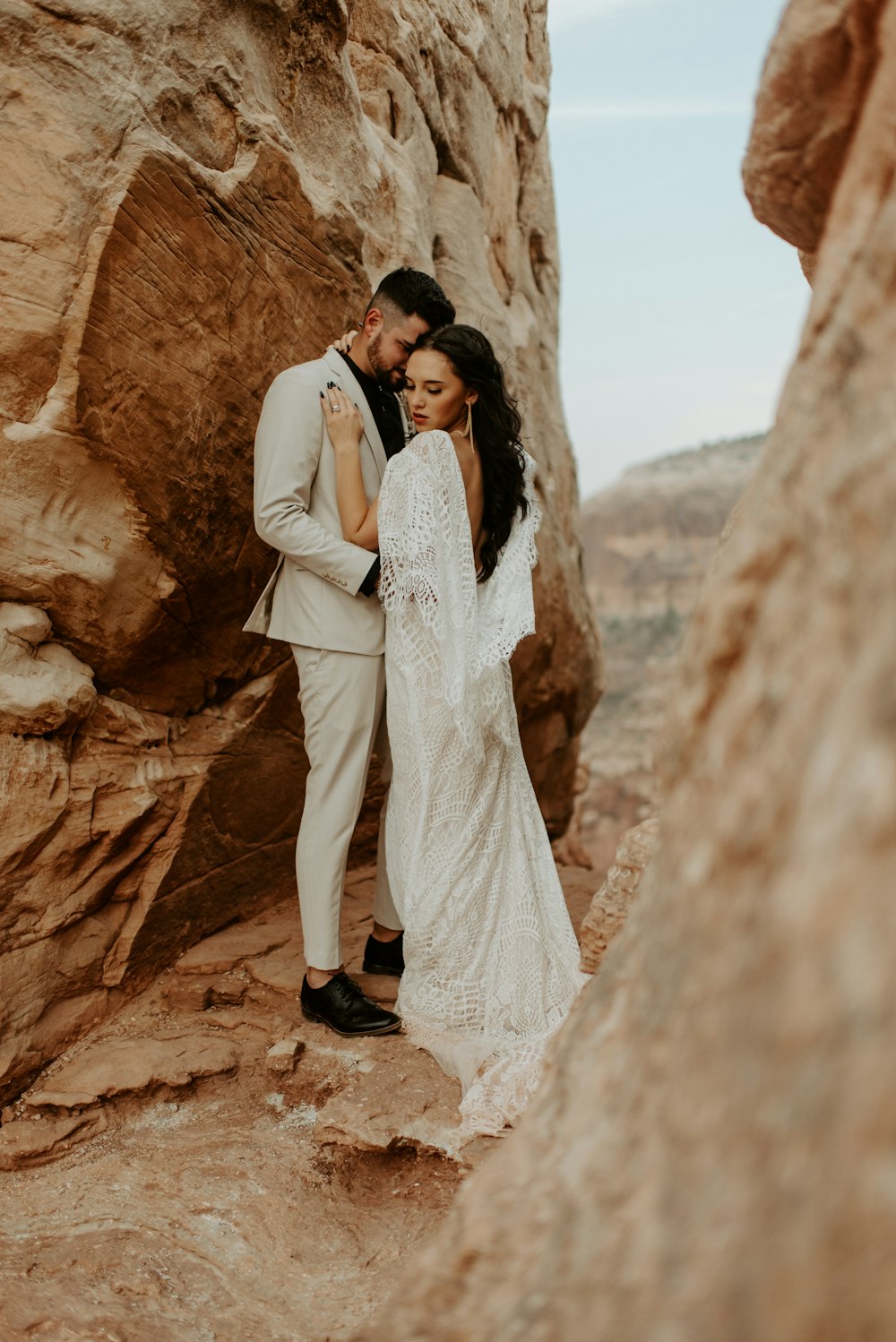 man and woman standing on brown rock formation during daytime