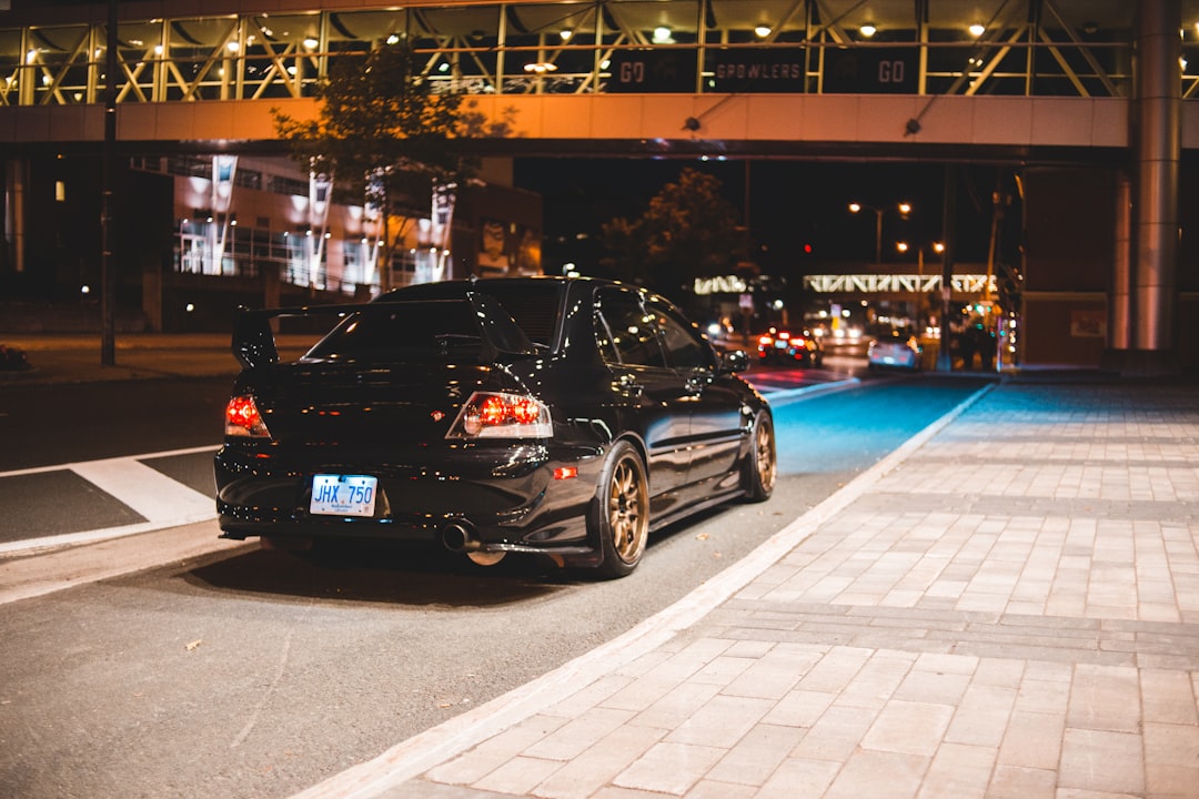 black sedan on parking lot during night time