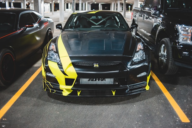 A sleek black and yellow car being serviced in a modern garage.