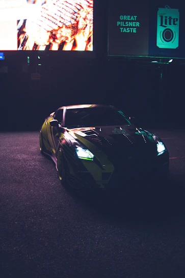 A sleek sports car parked under city lights with an influencer filming content nearby.