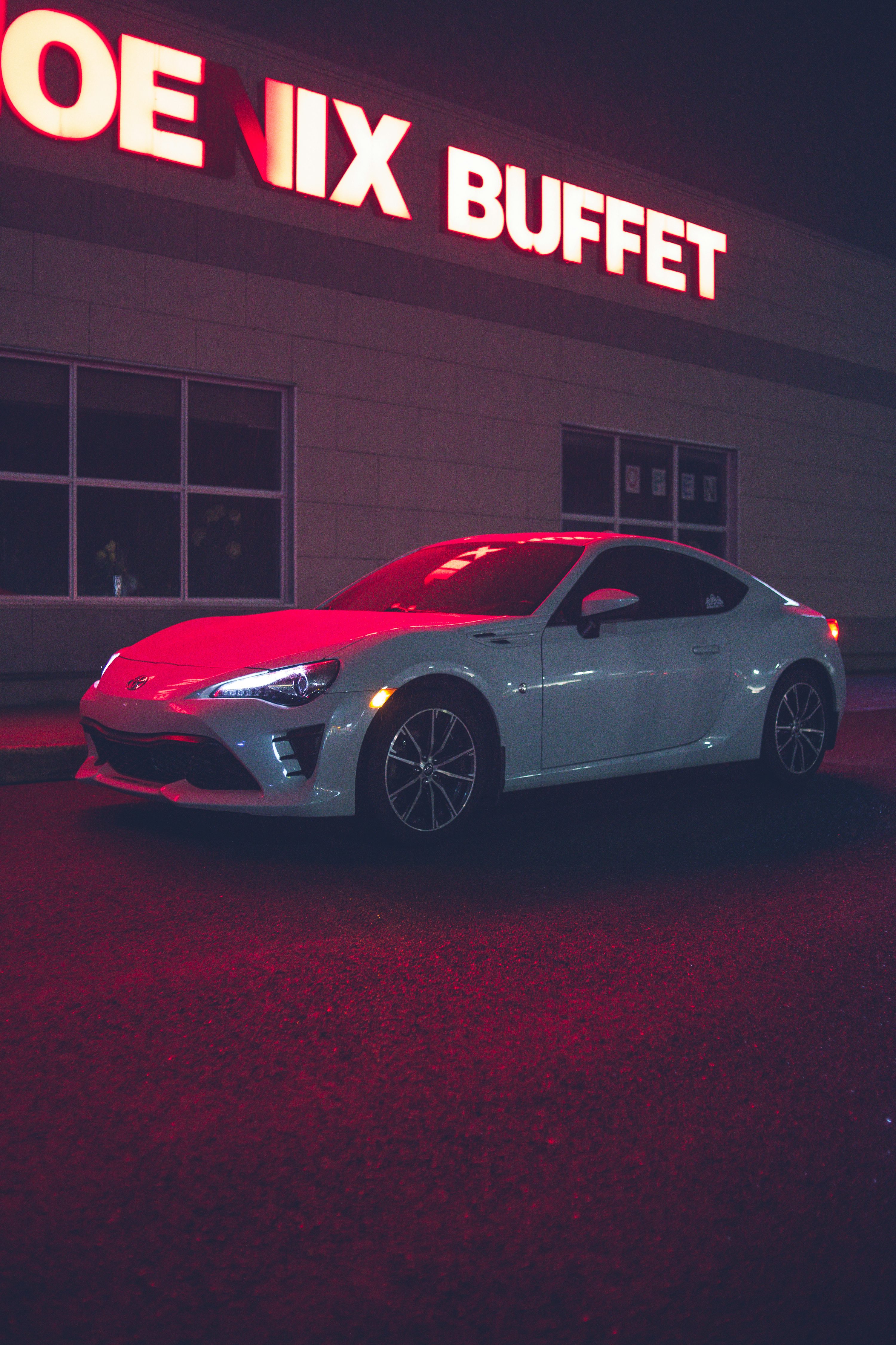 a white sports car parked in front of a store