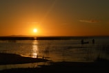 Sunset over the Amazon River with canoes gently floating near the shore.
