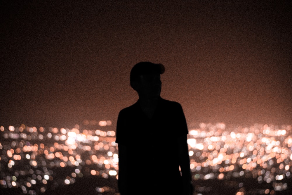 man in black suit standing during night time