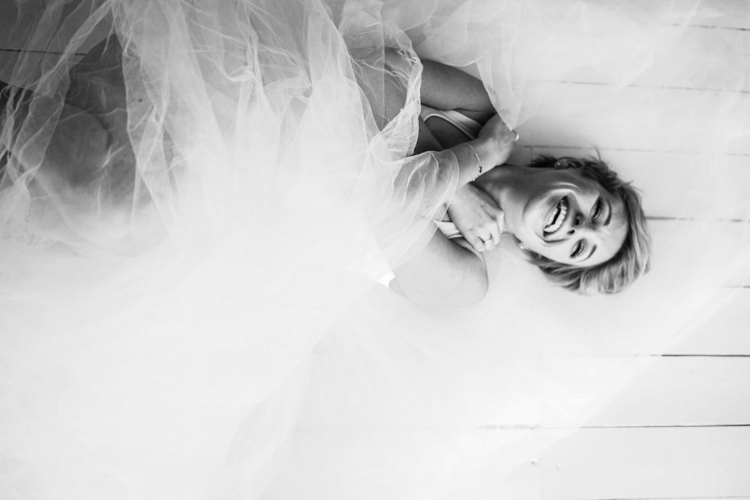 grayscale photo of woman lying on bed