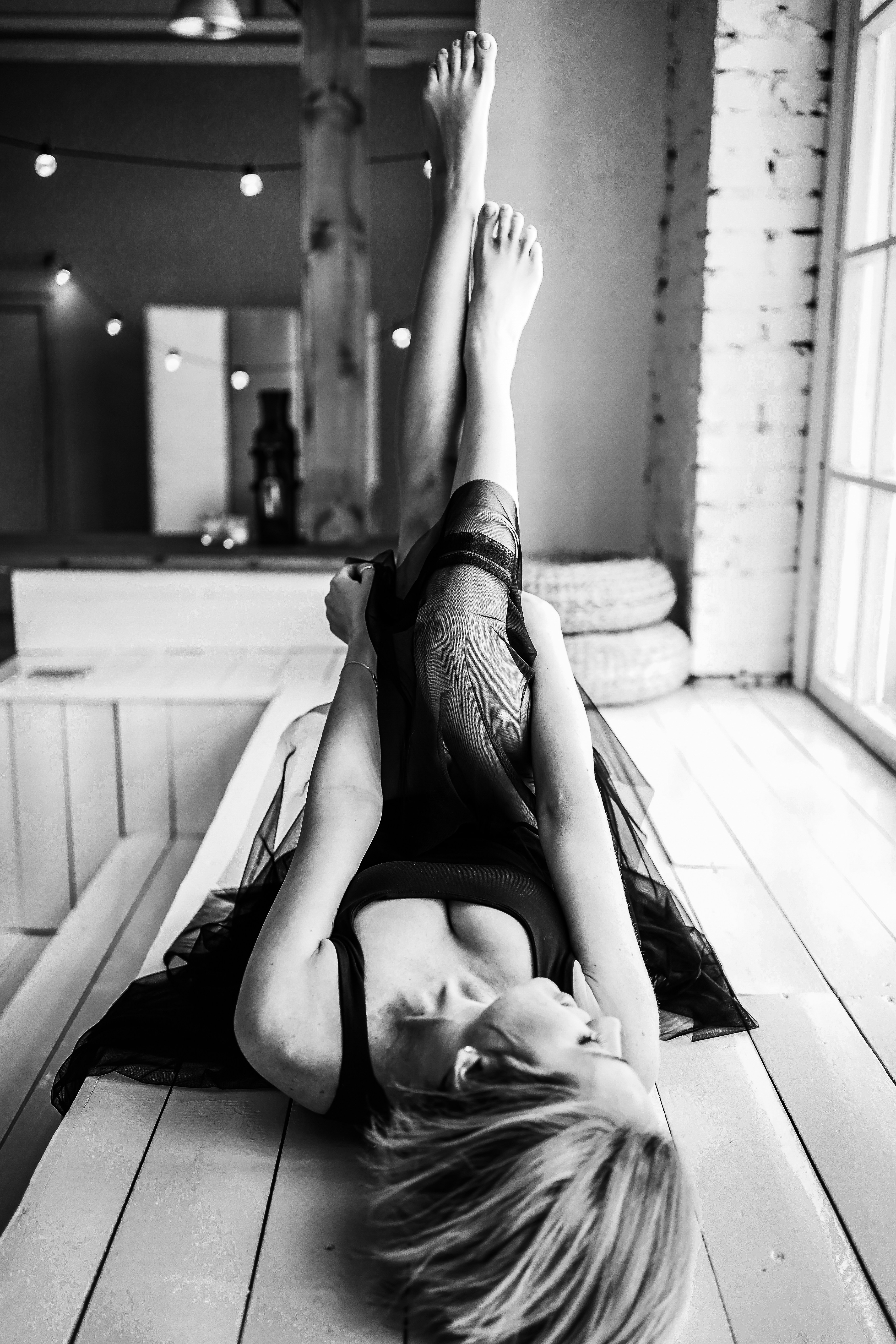 Grayscale photo of woman lying on bed
