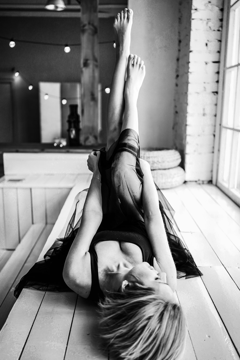 grayscale photo of woman lying on bed