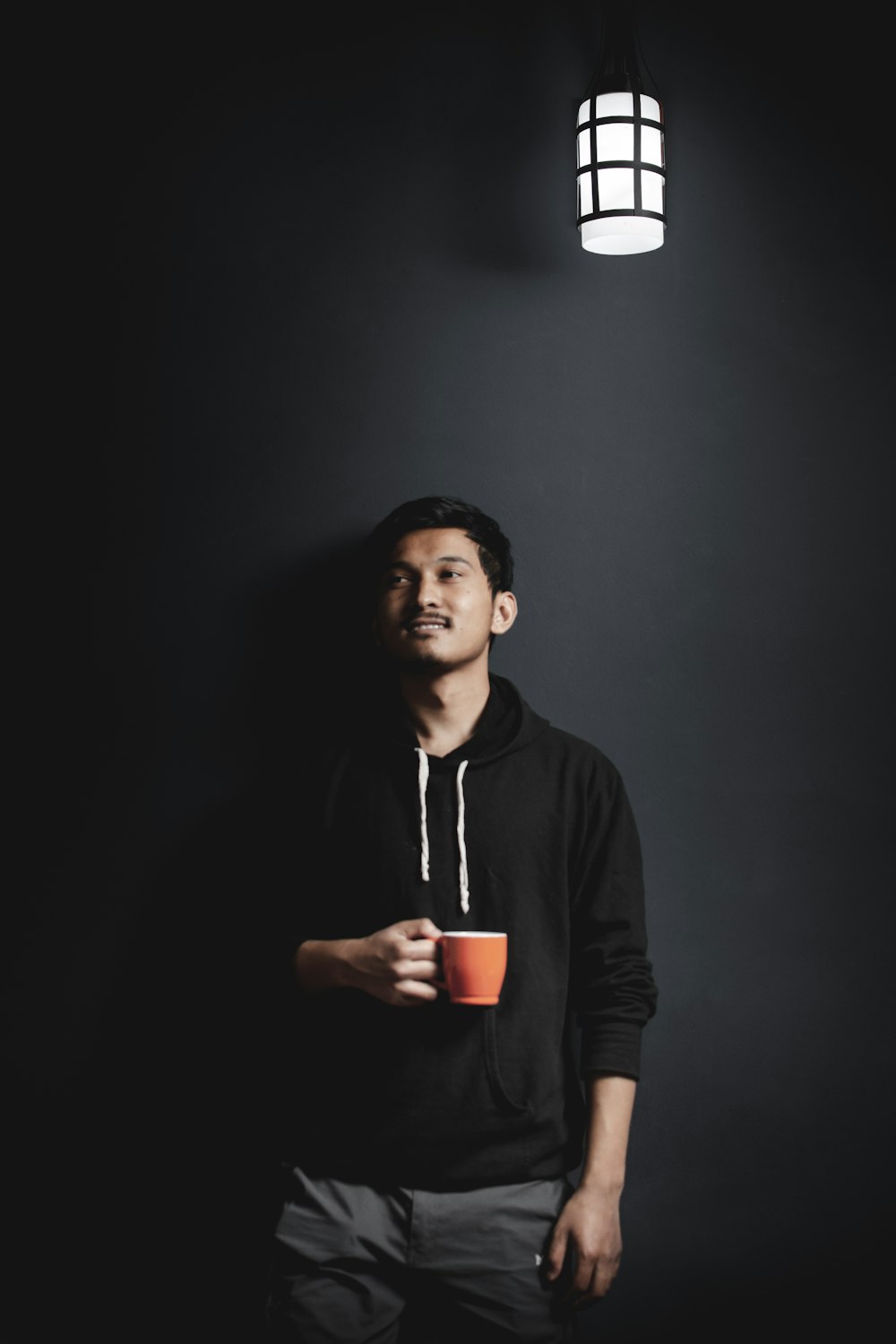 man in black hoodie holding red cup