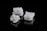 Three crystalline salt cubes are arranged against a sleek black background, showcasing their intricate geometric patterns and reflective surfaces.