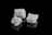Three crystalline salt cubes are arranged against a sleek black background, showcasing their intricate geometric patterns and reflective surfaces.