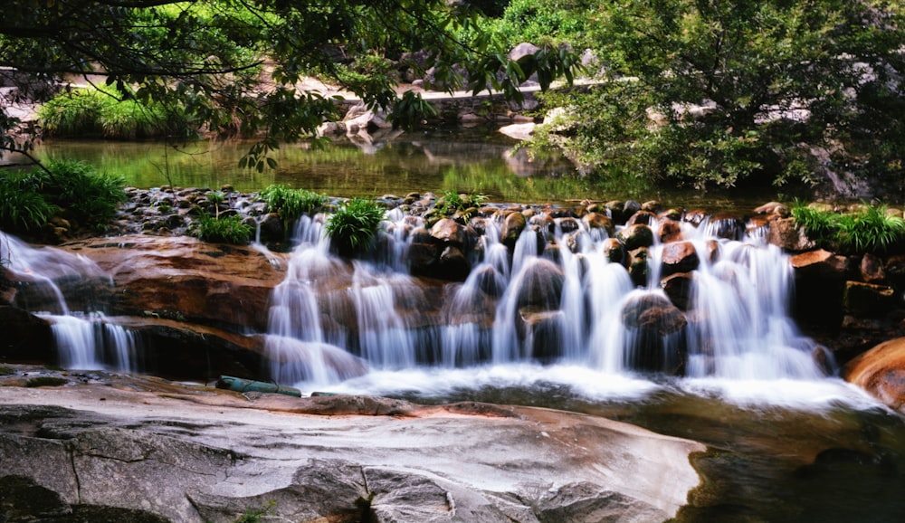 people in water falls during daytime