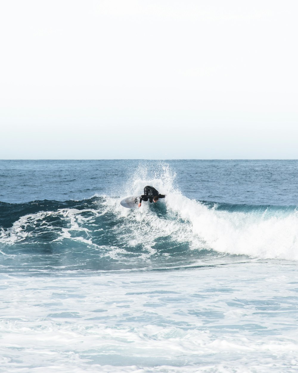 homme surfant sur les vagues de la mer pendant la journée