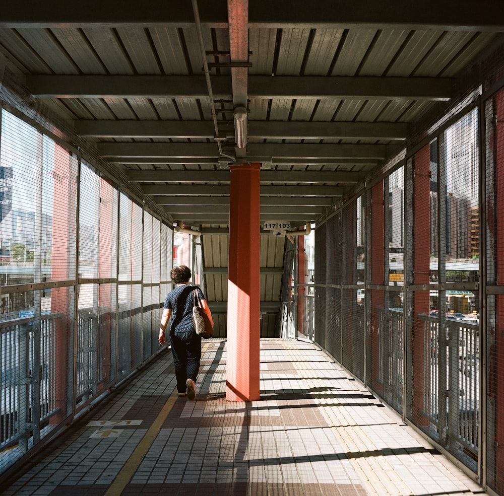 woman in black jacket walking on brown wooden floor