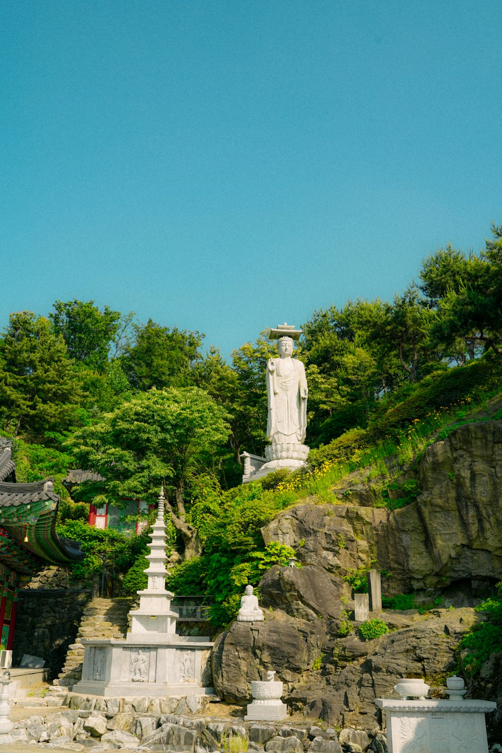 Statue en béton blanc au sommet de la montagne pendant la journée