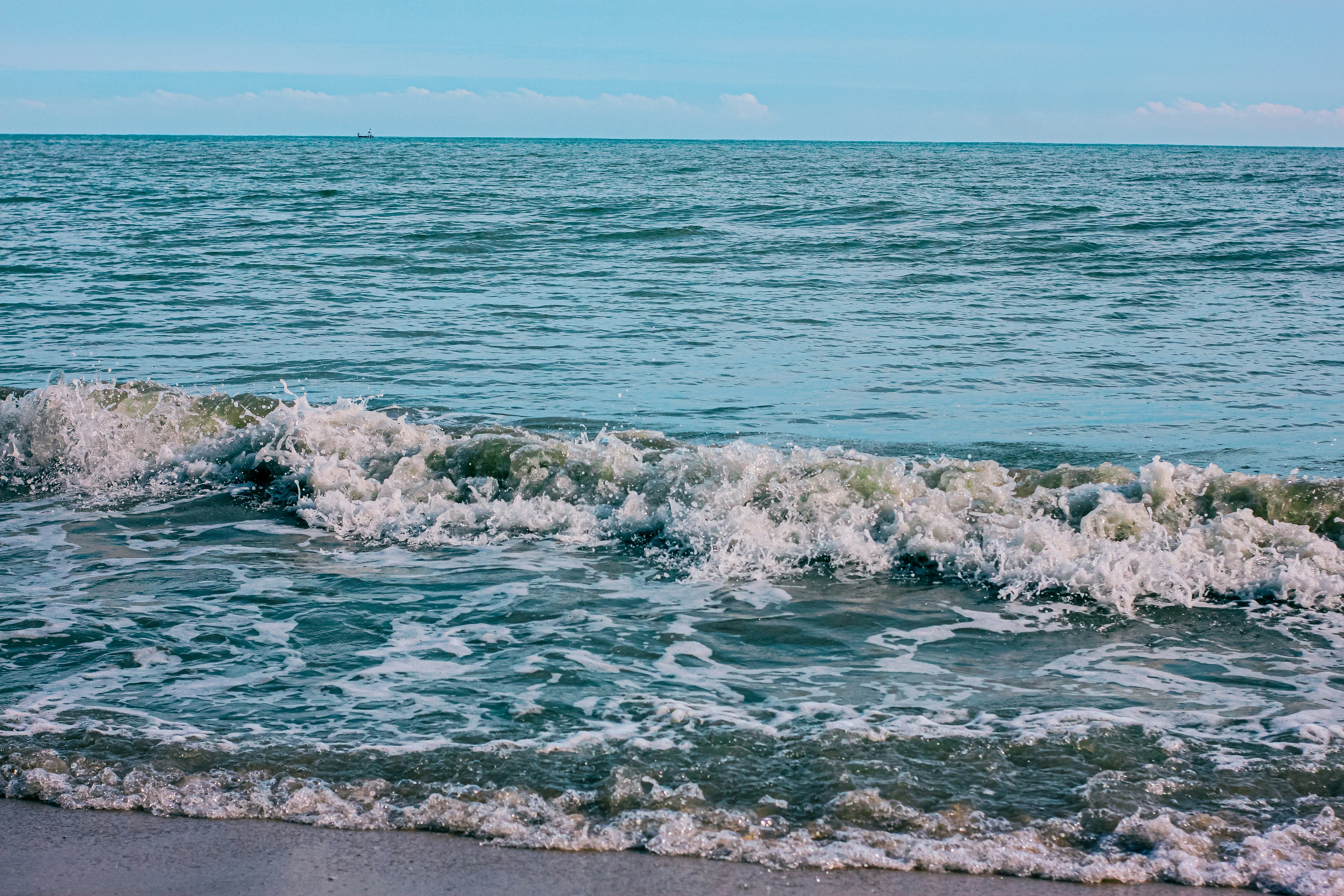 ocean waves crashing on shore during daytime