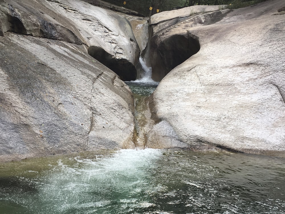 body of water between brown rocky mountains during daytime