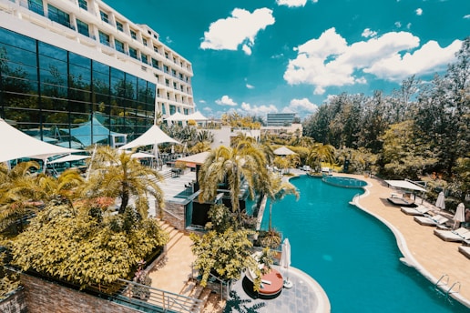 white and blue concrete building near green trees and body of water during daytime