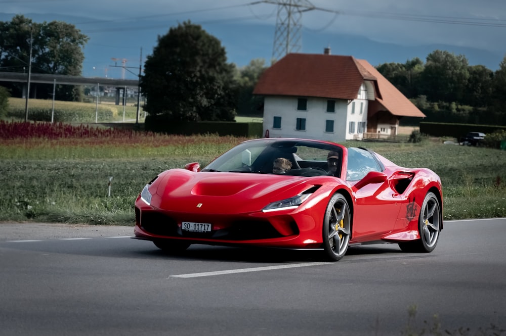 Ferrari 458 Italia rojo en la carretera cerca de Brown House durante el día