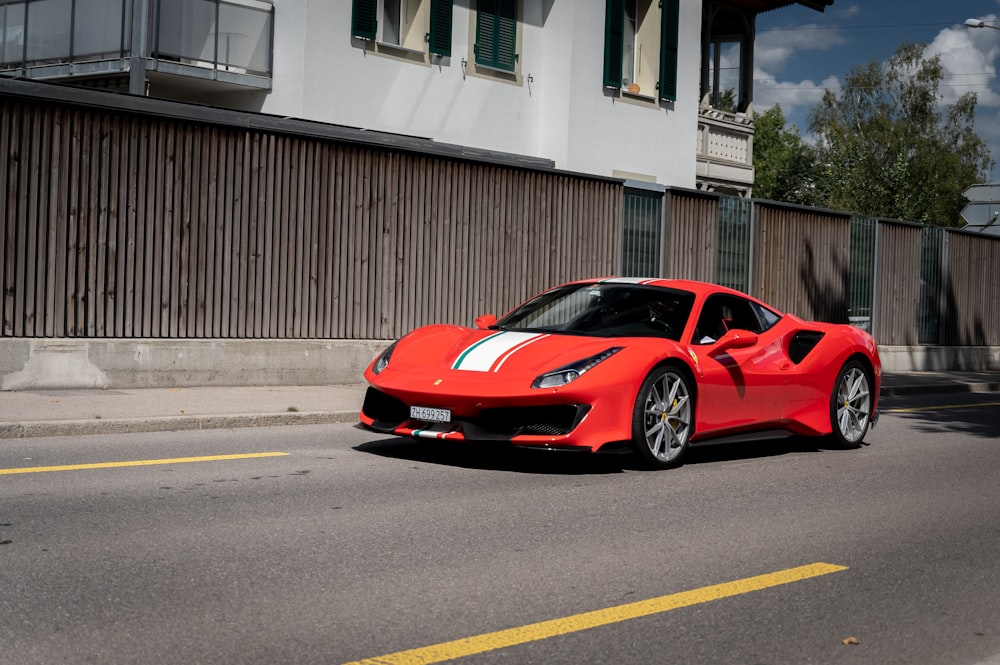 red ferrari 458 italia parked on road near white building