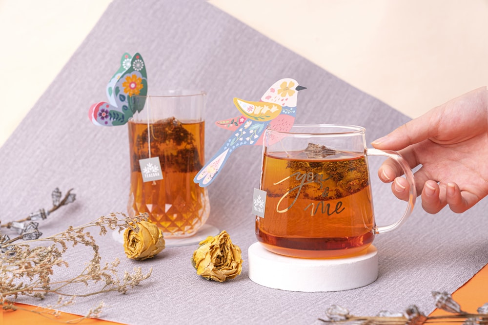 clear glass mug with brown liquid inside