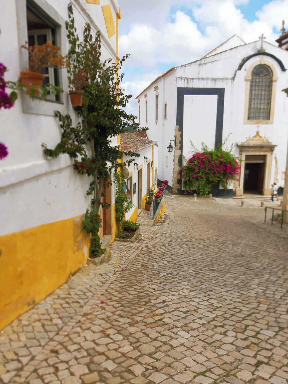 woman in yellow shirt walking on sidewalk during daytime