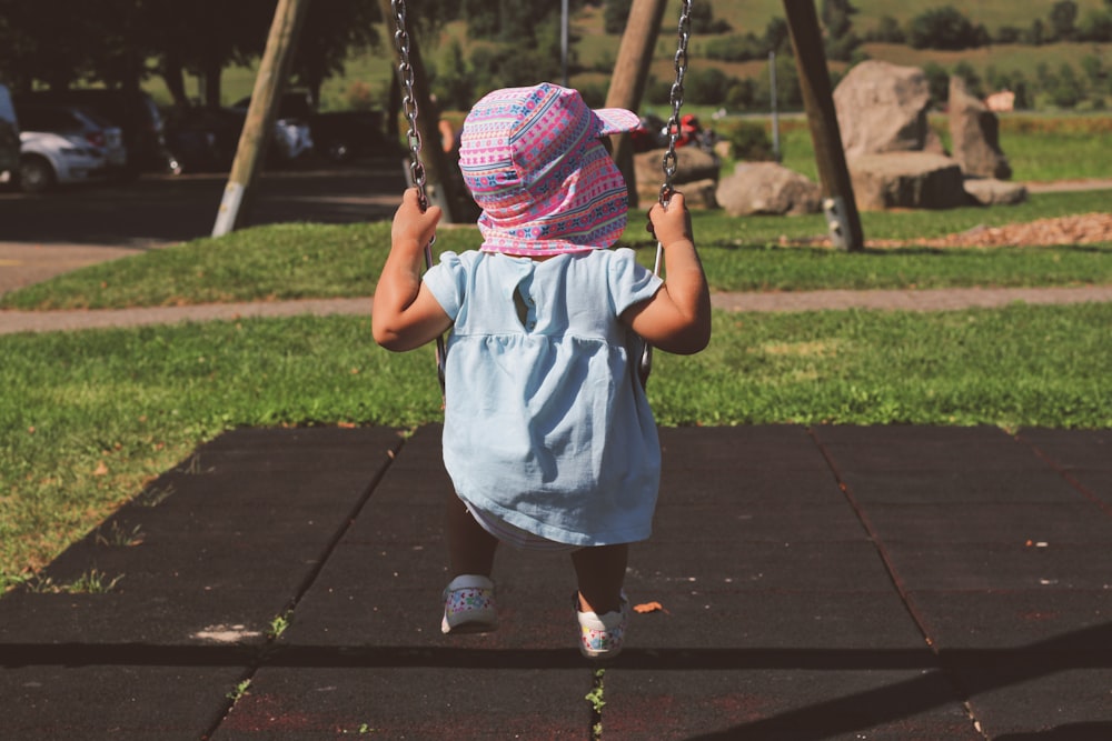 a little girl on a swing in a park