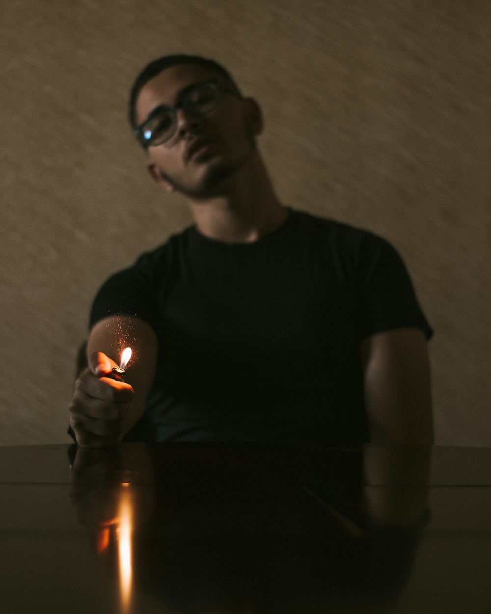 a man sitting at a table holding a lit candle