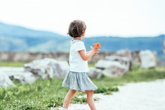 a little girl that is holding a flower