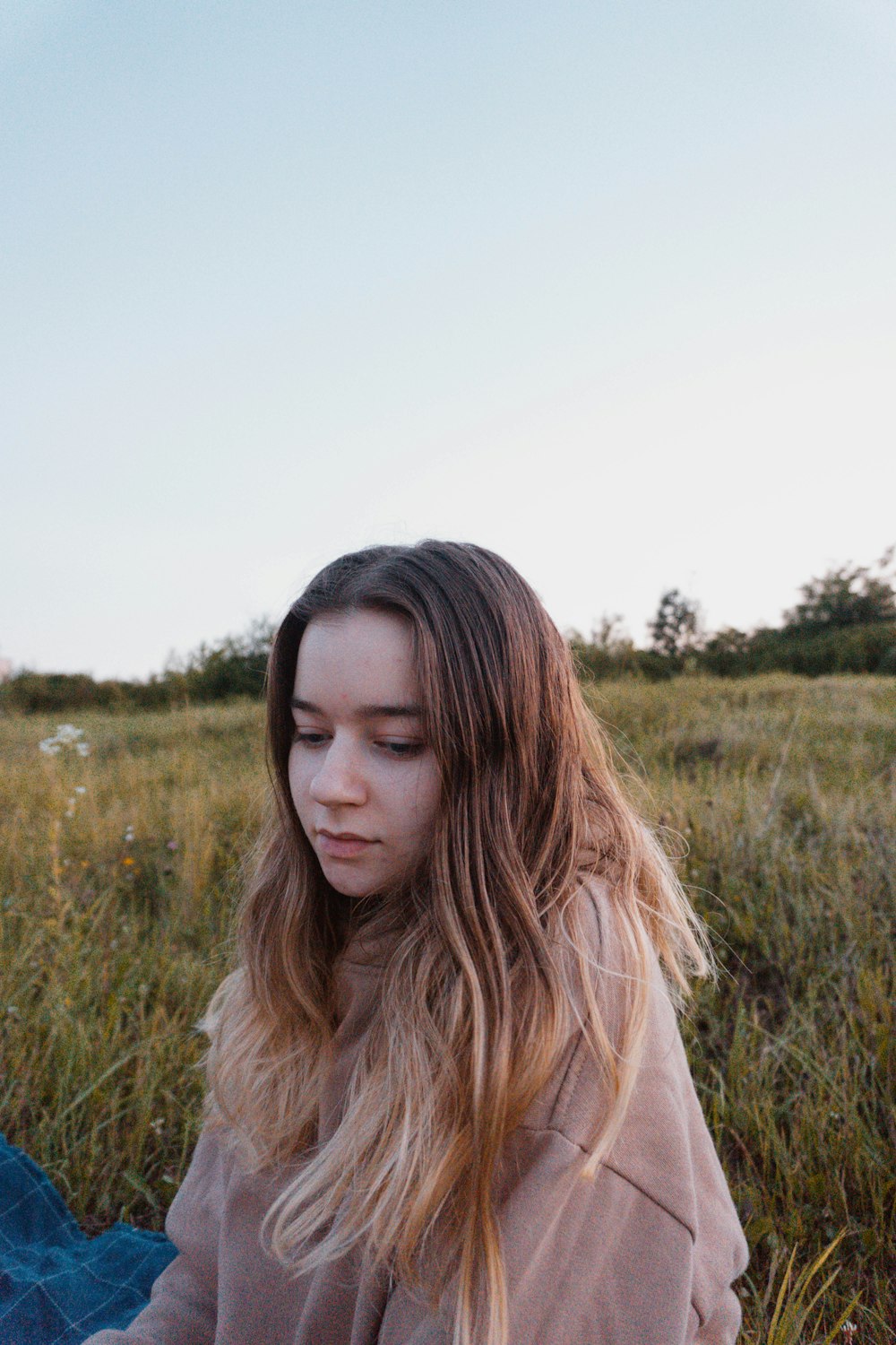 a woman sitting in a field of tall grass