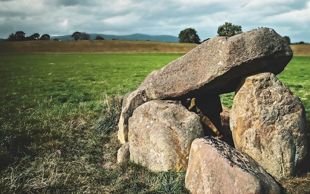 gray rock formation on green grass field during daytime