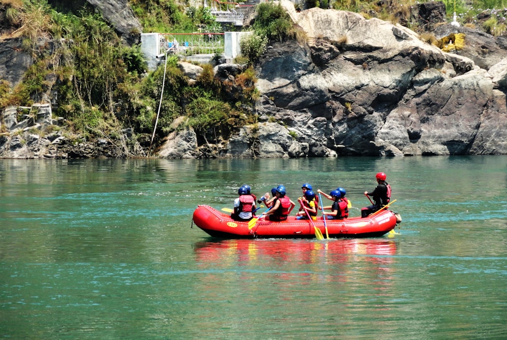 personnes faisant du kayak rouge sur la rivière pendant la journée